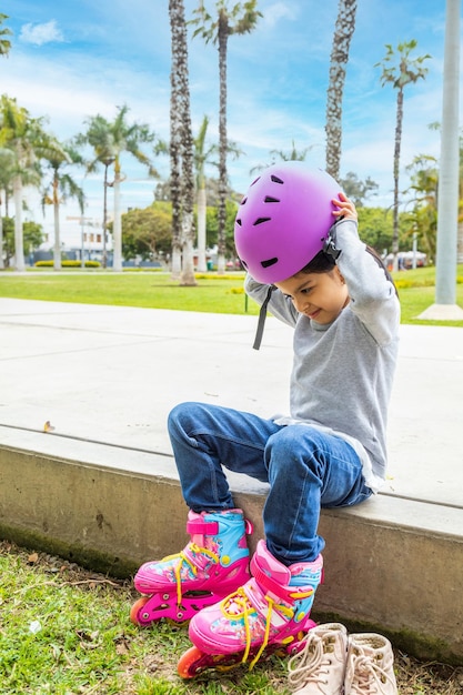 Little girl is putting on her protective helmet to skate