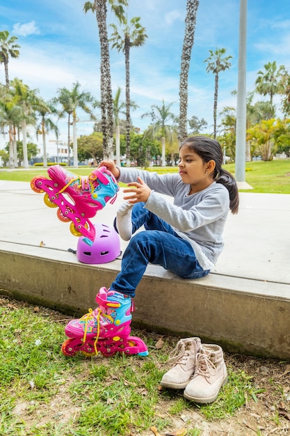 Little girl is putting on her roller skates