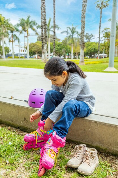 Little girl is putting on her roller skates