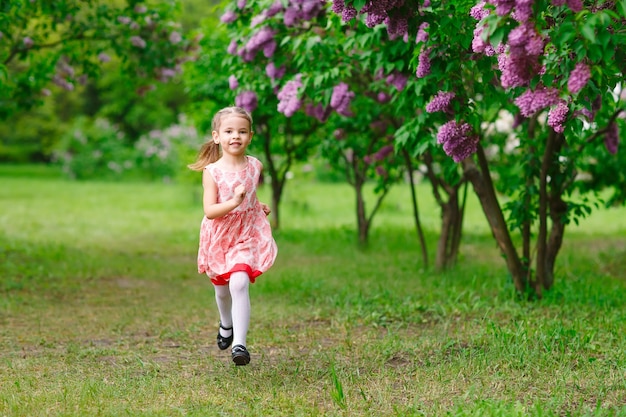 A little girl is running in the park.