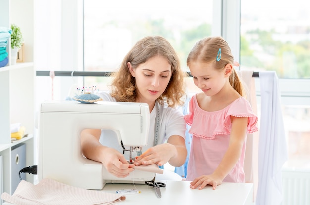 Little girl is taught to sew