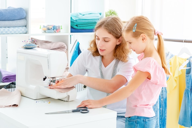 Little girl is taught to sew