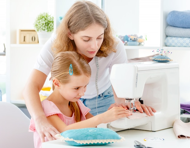 Little girl is taught to sew