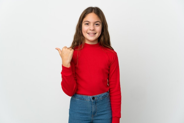 Little girl over isolated white pointing to the side to present a product