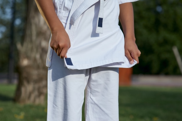 Little girl karateka wearing white karate kimono