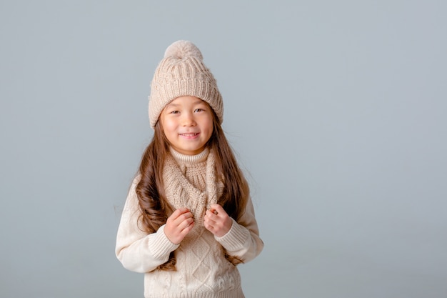 Little girl knitted hats and scarf isolated on white background