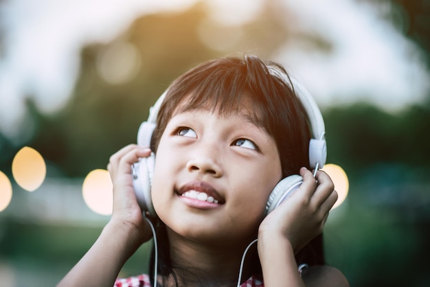 Little girl listening music in the park