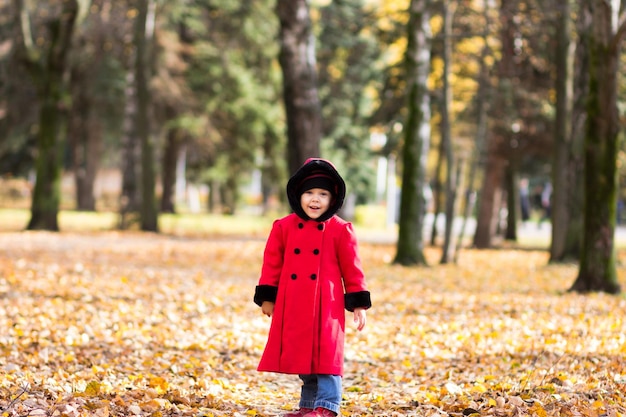 Little girl looking at camera in autumn park