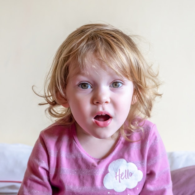 A little girl looks at the camera and grimaces.