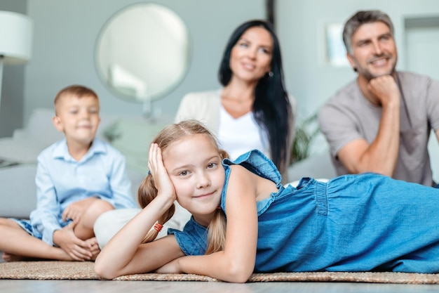 Little girl lying on the floor in front of her family