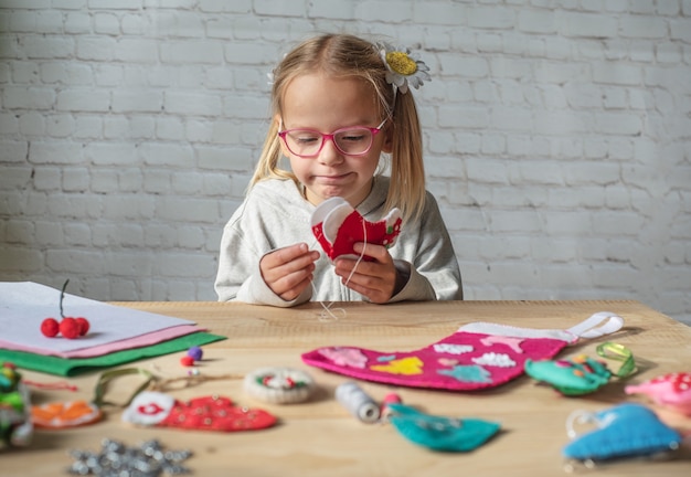 Little girl making Christmas felt decoration, Christmas crafting