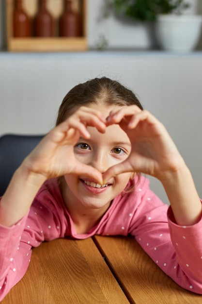 Little girl making hearts from hands love