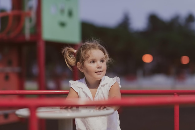 A little girl in modern summer clothes playing in the park in summer selective focus