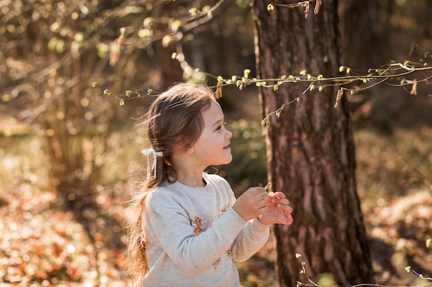 little girl on nature examines plants