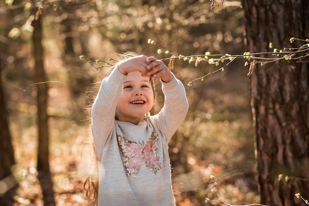 little girl on nature examines plants