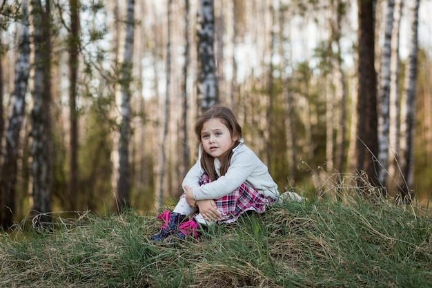 little girl in nature is sad and bored