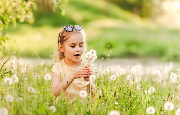 Little girl outside on dandelion field