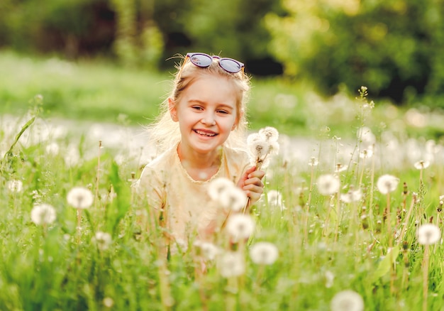 Little girl outside on dandelion field