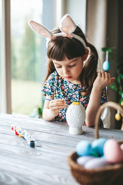 Little girl painting Easter egg