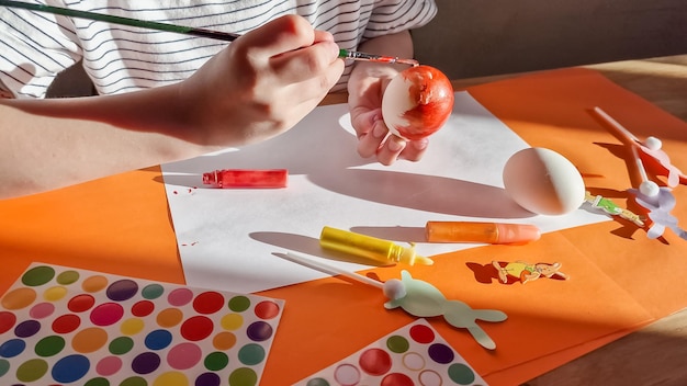 Little girl painting eggs for Easter at home in kindergaten or preschool Celebrating holidays with children Creative activities and games for kids Stay at home entertainment