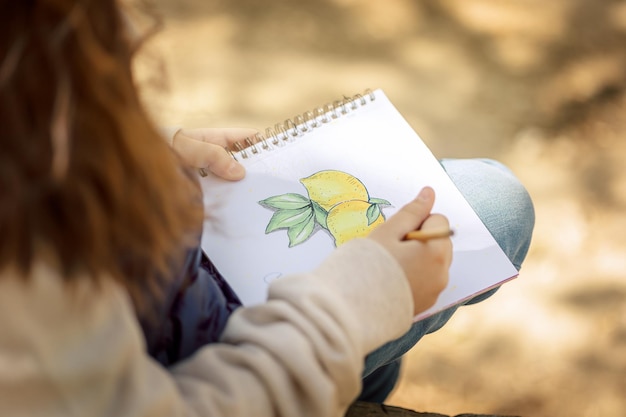 Little girl paints in open air in spring blooming fairytale park Children39s drawings Creative kid Joy of childhood