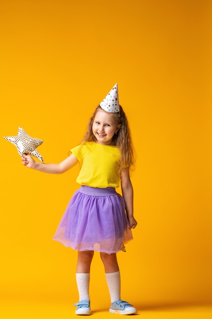 Little girl in a party hat with a balloon