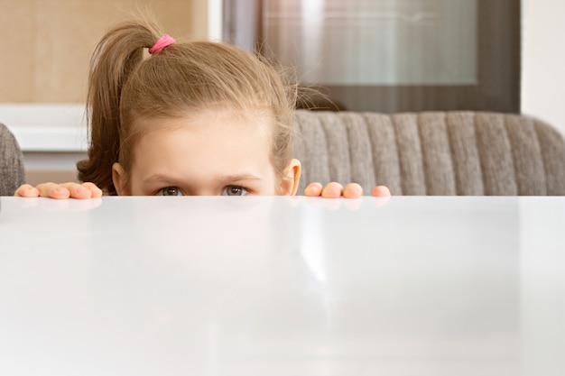 Little Girl Peeking From Behind Table, copy space