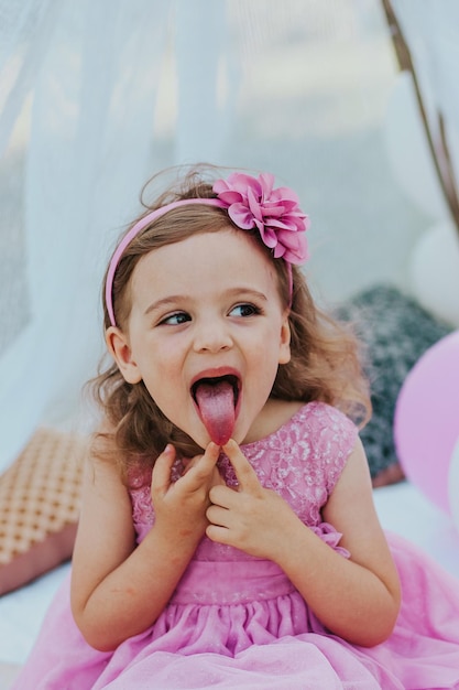 little girl in pink dress having fun in garden