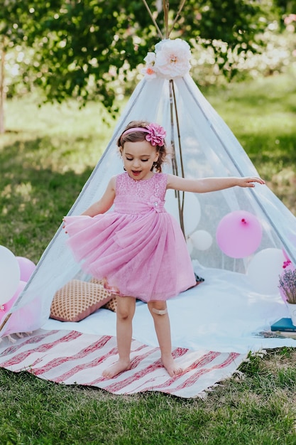 little girl in pink dress having fun in garden