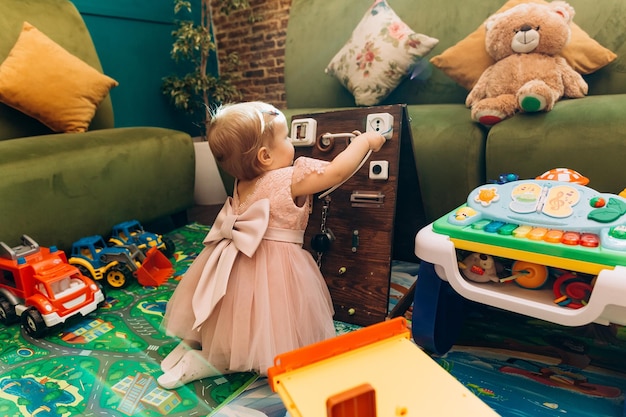 Little girl playing inside toy house educational