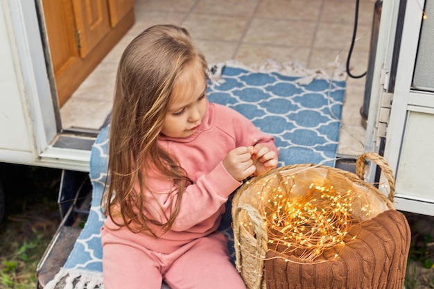 Little girl playing on the steps of a travel trailer