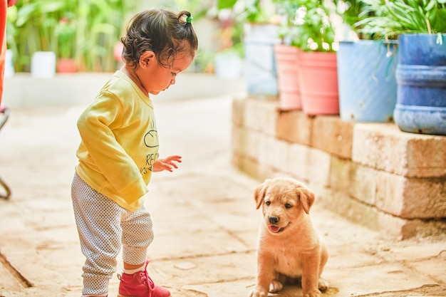 Little girl playing with her puppy