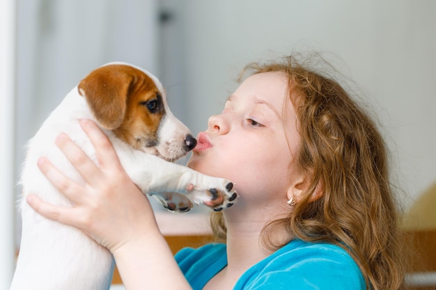 Little girl playing with puppy jack russell