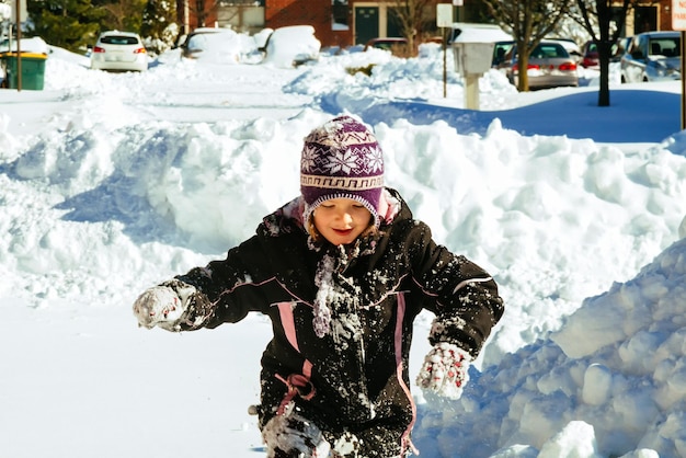 Little girl playing with snow little girl playing in the street with snow