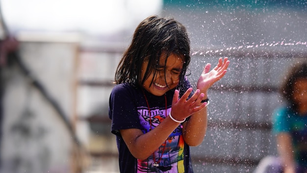 A little girl playing with water with her friends