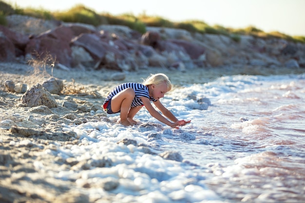 Little girl plays at the seashore