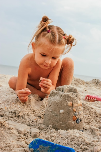 Little girl plays with sand on the beach