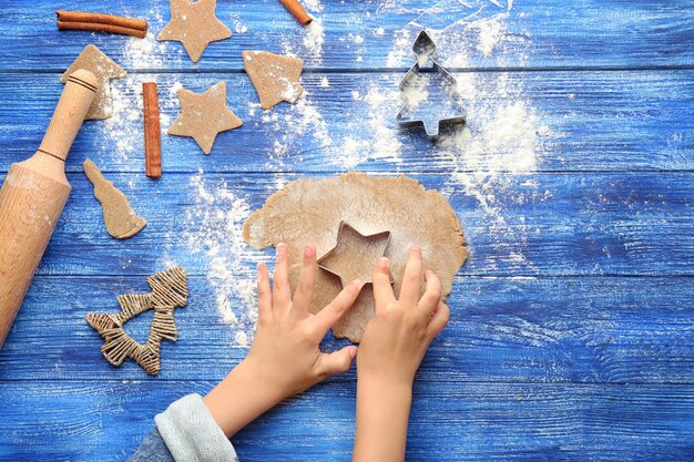 Little girl preparing Christmas cookies at table