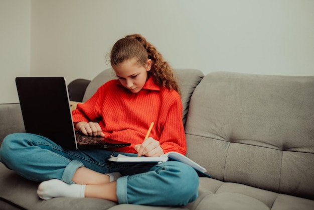 Little girl a preschooler uses a laptop to study at home the child smiles happily and receives knowledge remotely digital concept of elearning Distance elearning