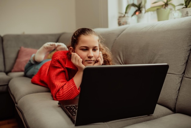 Little girl a preschooler uses a laptop to study at home the child smiles happily and receives knowledge remotely digital concept of elearning Distance elearning