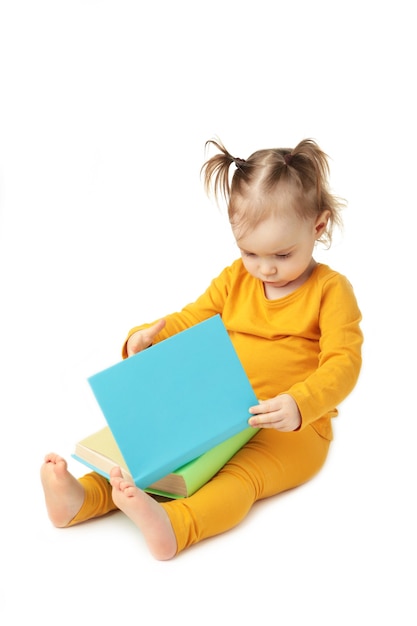 Little girl reading isolated on white. Cute baby with book. Top view