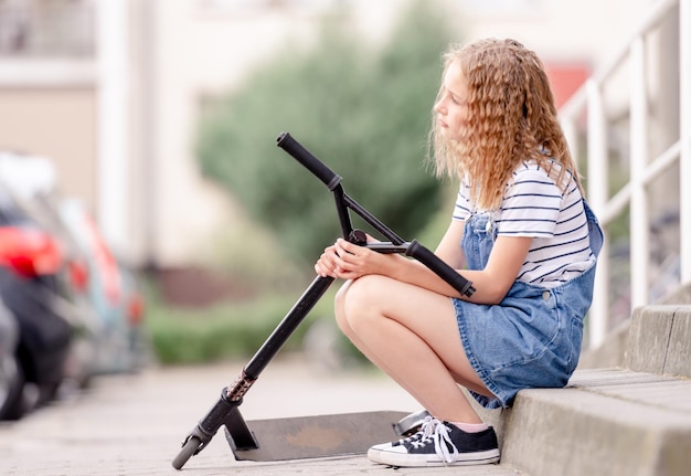 Little girl rides a kick scooter