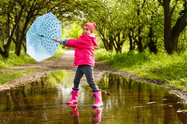 little girl riding bike in water puddle