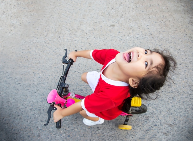 little girl riding bycicle on the street