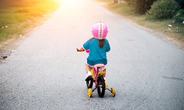 little girl riding bycicle on the street