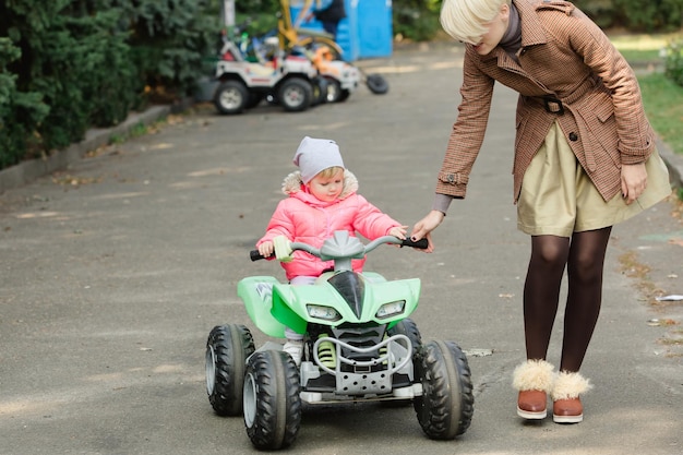 Little girl riding toy car in park