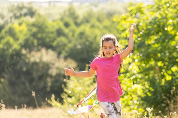 little girl running outdoor with a kite