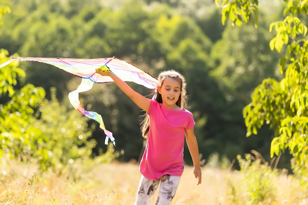 little girl running outdoor with a kite