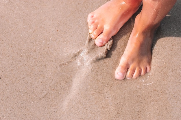 Little girl's feet on a sand