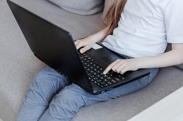 little girl's hand on a laptop keyboard The concept of using the younger generation of gadgets